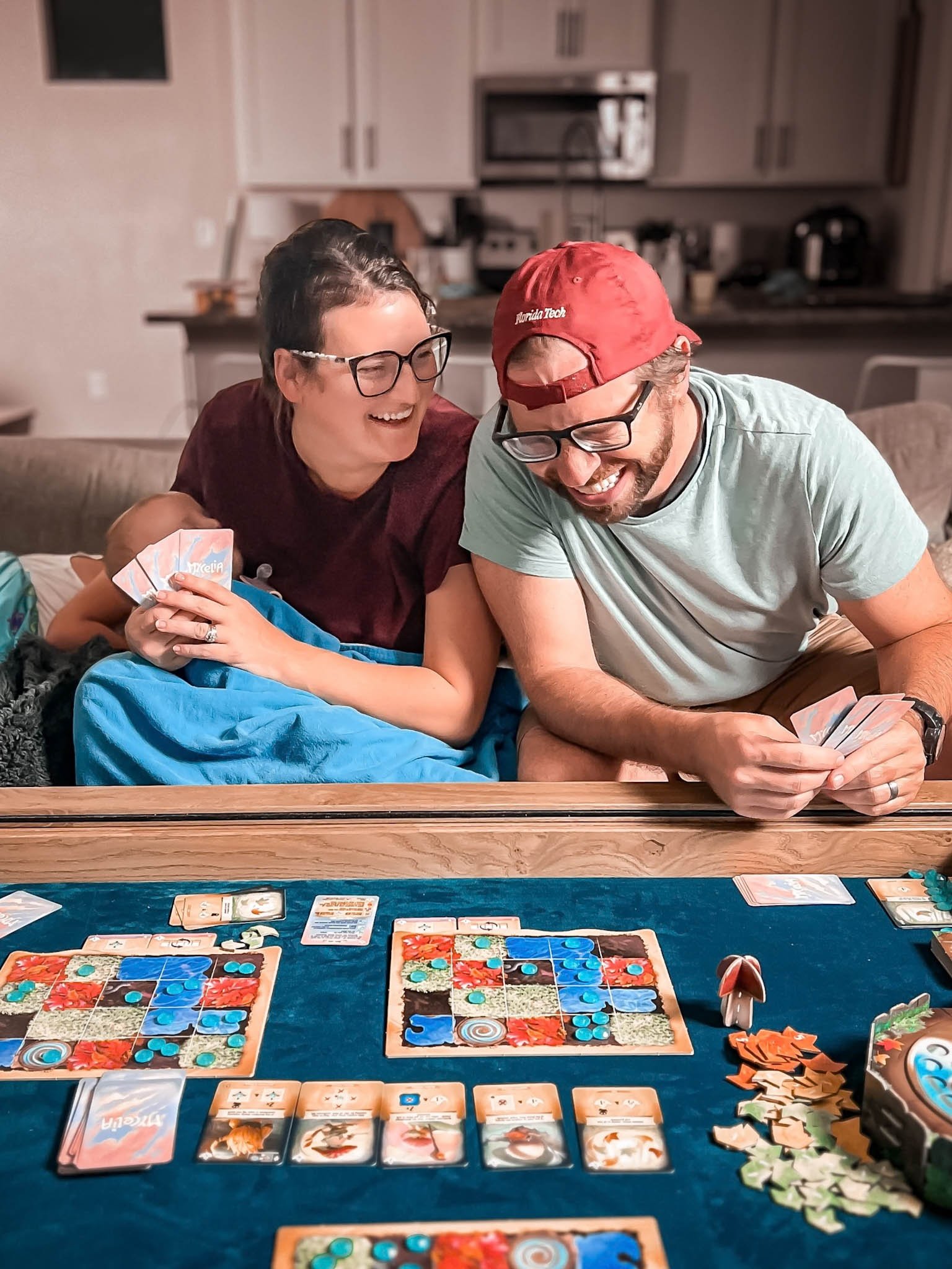 Tabletop Family, Adam and Kelsey playing aboard game with baby